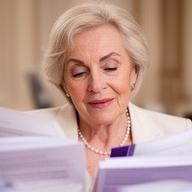 Abogada senior en un despacho elegante de Madrid, revisando un expediente de familia junto a notas manuscritas